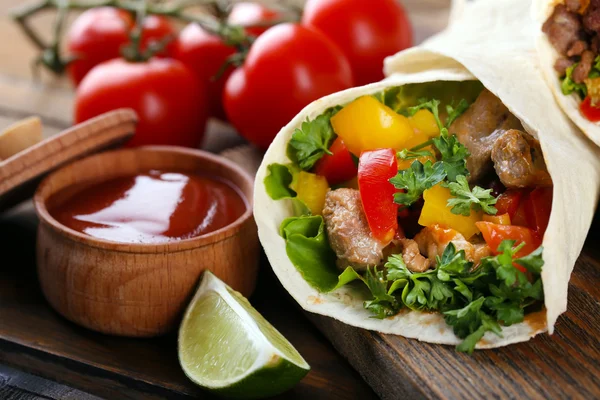 Hemgjord Mumsiga burrito med grönsaker på skärbräda, på trä bakgrund — Stockfoto