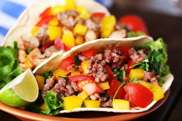 Hemlagad biff burritos med grönsaker på tallriken, på trä bakgrund — Stockfoto