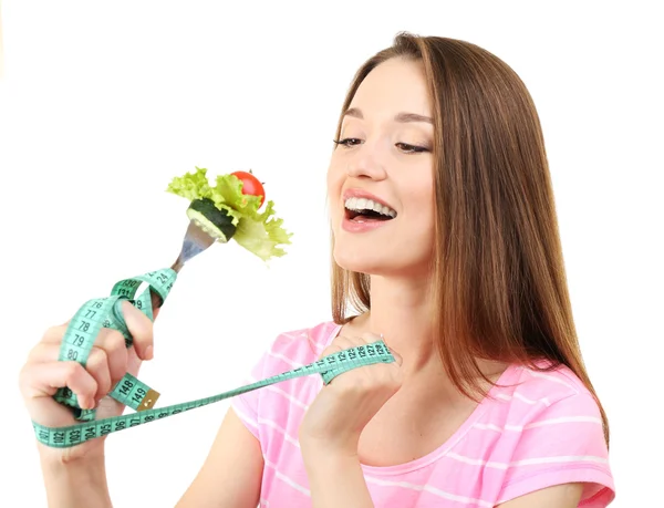 Mulher jovem saudável com legumes em garfo e fita métrica isolada em branco — Fotografia de Stock