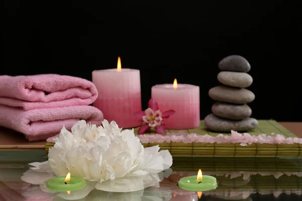 Spa ainda vida com flor e luz de velas em fundo preto — Fotografia de Stock