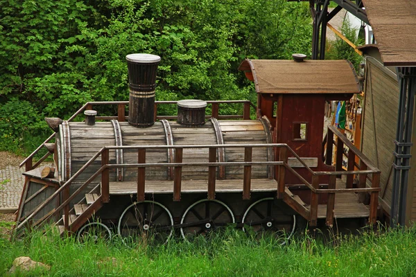 Wooden locomotive over green trees in park — Stok fotoğraf