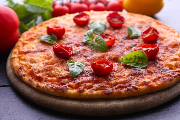 Pizza con basilico e pomodorini su tagliere di legno, primo piano — Foto Stock