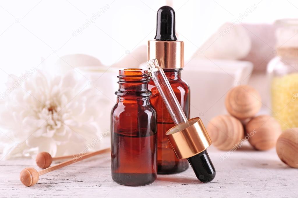 Spa dropper bottles with essence on wooden table, closeup