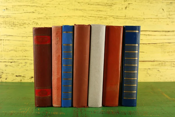 Pilha de livros sobre fundo de madeira — Fotografia de Stock