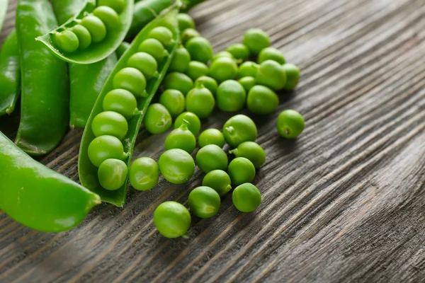 Guisantes verdes frescos en mesa de madera, primer plano — Foto de Stock