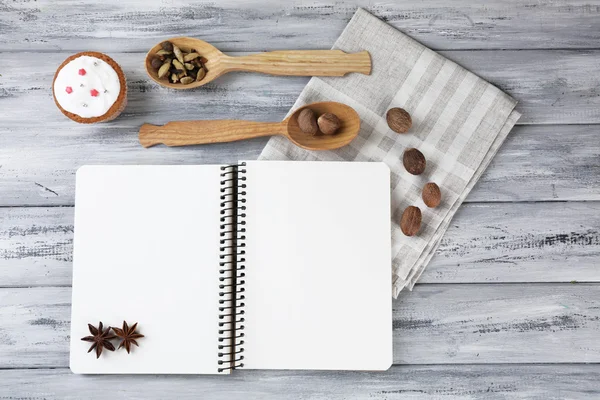 Livro de receitas aberto e padaria saborosa em fundo de madeira — Fotografia de Stock