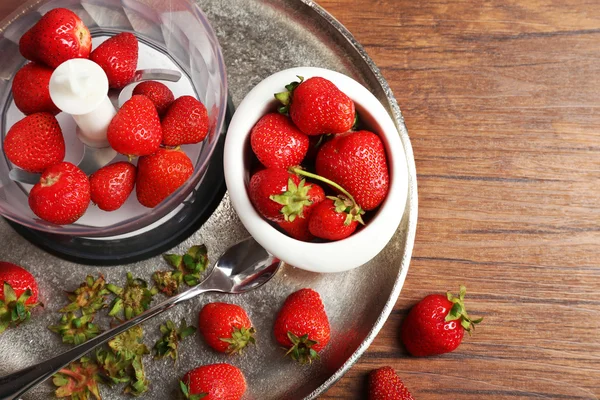 Fraises mûres dans mélangeur sur plateau en métal sur table en bois, vue de dessus — Photo