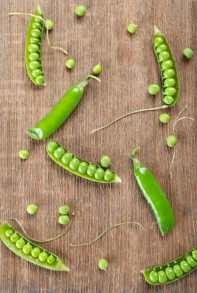 Guisantes verdes frescos sobre fondo de madera —  Fotos de Stock