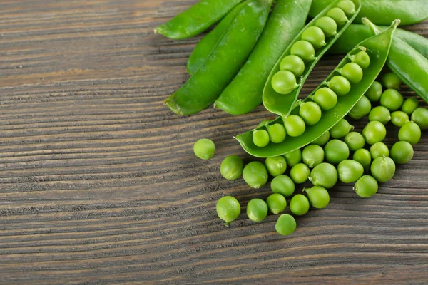 Guisantes verdes frescos en mesa de madera, primer plano — Foto de Stock