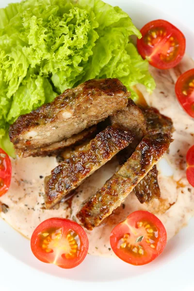 Tranches de viande savoureuses avec sauce et tomate cerise dans une assiette close up — Photo