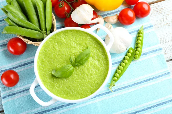 Tasty peas soup and vegetables on table close up — Stock Photo, Image
