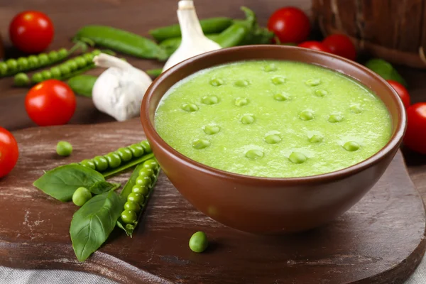 Tasty peas soup and vegetables on table close up — Stock Photo, Image