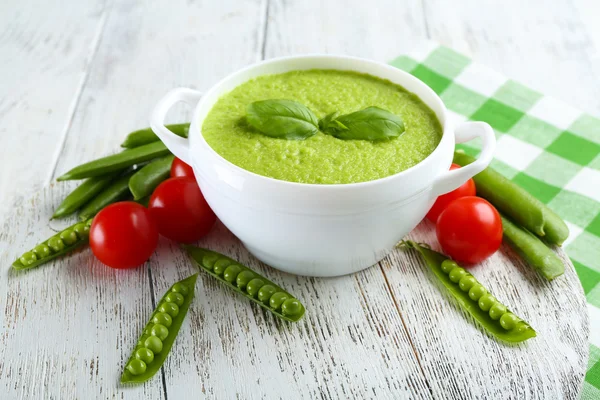 Tasty peas soup and cherry tomatoes on table close up — Stock Photo, Image