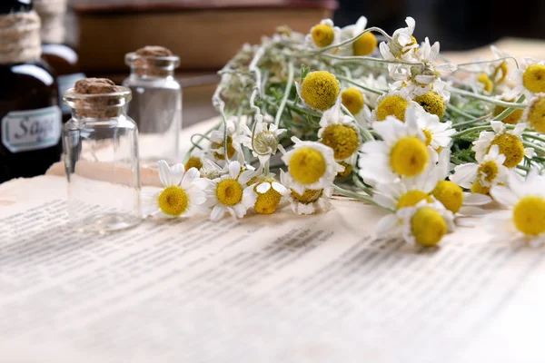 Libro viejo con flores secas y botellas en la mesa de cerca —  Fotos de Stock