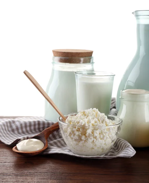 Produtos lácteos em mesa de madeira sobre fundo branco — Fotografia de Stock