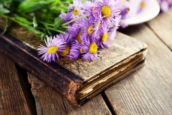 美しい花と木製のテーブル上の古い本をクローズ アップ — ストック写真