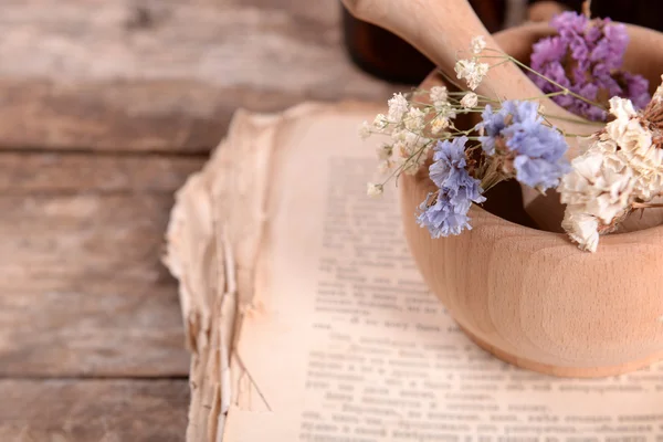 モルタルの乾燥した花とテーブルの上の古い本をクローズ アップ — ストック写真