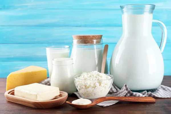 Dairy products on wooden table on blue  background — Stock Photo, Image