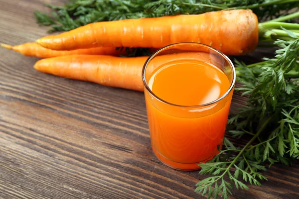 Vaso de jugo de zanahoria con verduras en la mesa de madera de cerca —  Fotos de Stock