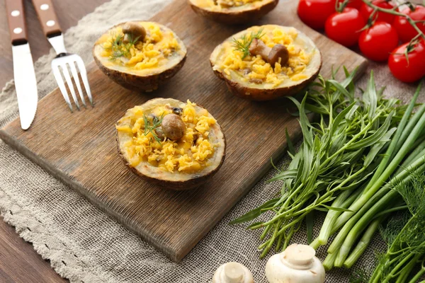 Batatas assadas com queijo e cogumelos na mesa de perto — Fotografia de Stock