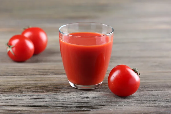 Szklankę soku pomidorowego z warzywami na drewnianym stole z bliska — Zdjęcie stockowe