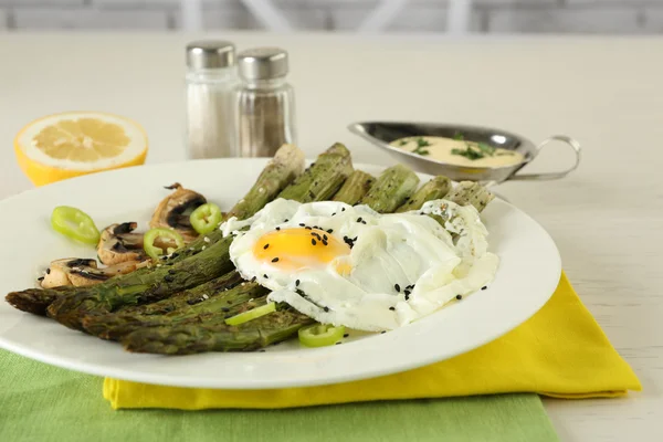 Rostad sparris med pocherat ägg på plattan på tabellbakgrund — Stockfoto