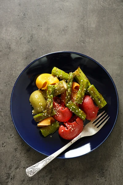 Смажена спаржа та смачна барвиста паста з овочами на тарілці на барвистому фоні — стокове фото