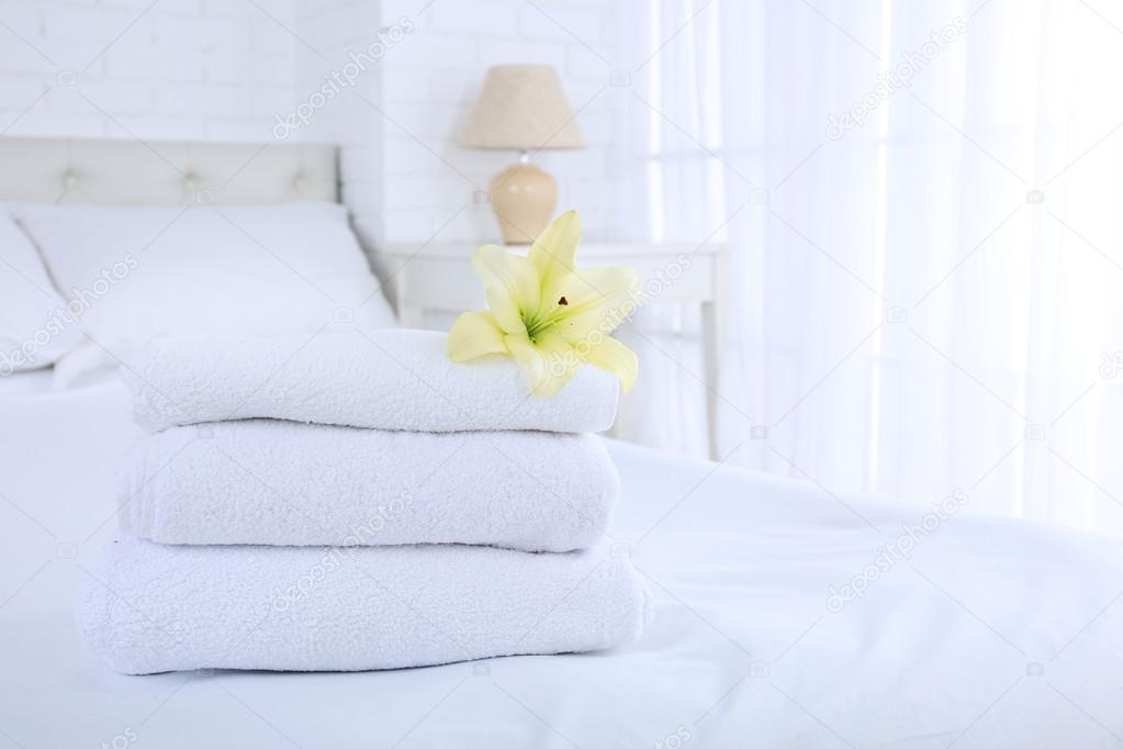 Freshly laundered fluffy towels in bedroom interior