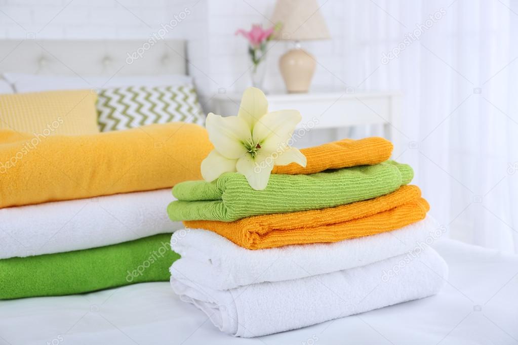 Freshly laundered fluffy towels in bedroom interior