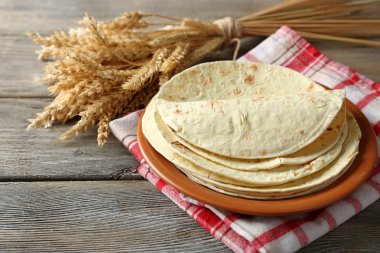 ev yapımı kepekli un tortilla ahşap masa arka plan üzerinde plaka üzerinde yığını