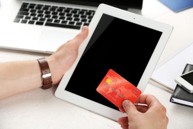 Kredi kartı ve tablet işyeri arka planda tutan adam