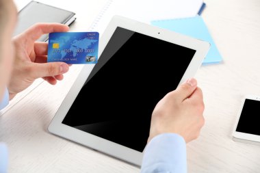 Kredi kartı ve tablet işyeri arka planda tutan adam