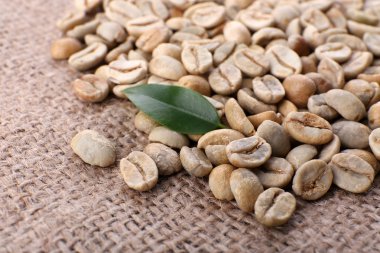 Yeşil kahve çekirdekleri ile çul yaprağına yığını kapat