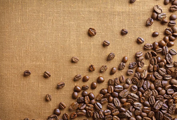 Quadro de grãos de café em fundo de pano de saco de cor — Fotografia de Stock