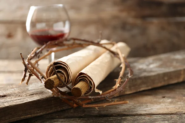 Crown of thorns, scroll and glass of wine on old wooden background — Stock Photo, Image