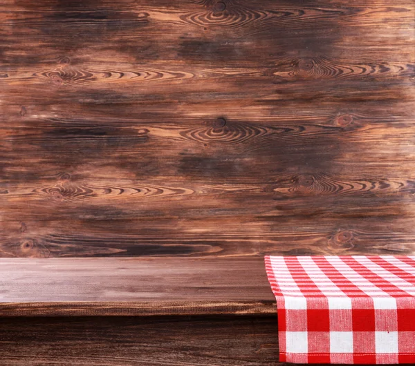 Empty wooden table with napkin on brown background — Stock Photo, Image