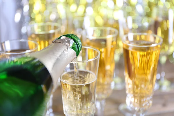 Pouring champagne from bottle into glasses — Stock Photo, Image