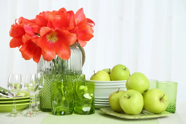 Bunte Tischdekorationen und Tulpenblumen in der Vase auf dem Tisch, auf hellem Hintergrund — Stockfoto