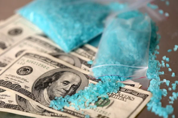 Drug laboratory: blue methamphetamine and money on table close up — Stock Photo, Image