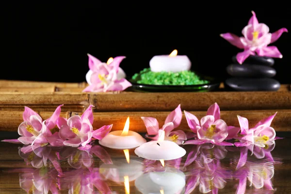 Beautiful spa composition with flowers and candles on black background — Stock Photo, Image