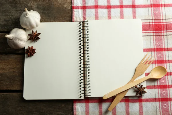 Open recipe book on napkin, on wooden background — Stock Photo, Image