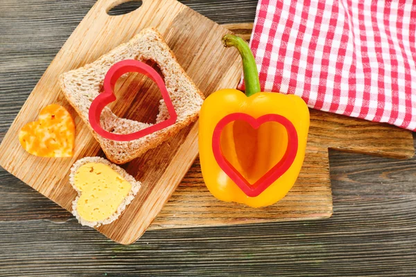 Sneetje brood met gesneden in de vorm van hart en peper op tafel close-up — Stockfoto