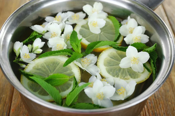 Kall uppfriskande sommardrink med mynta och skivor av citron i stekpanna på nära håll — Stockfoto