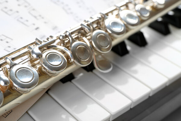 Флейта и фортепиано с нотами вблизи
