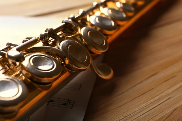 Ασημένια φλάουτο με σημειώνει μουσική στο ξύλινο τραπέζι από κοντά — Φωτογραφία Αρχείου