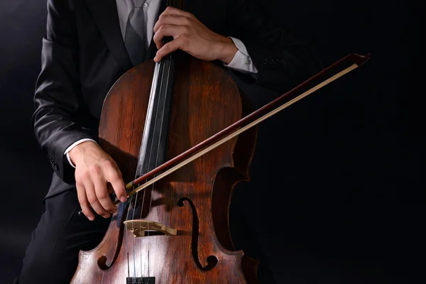 男の暗い背景にチェロ演奏 — ストック写真
