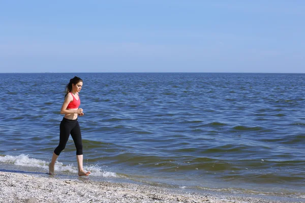 Young woman jogging on beach — Stock Photo, Image