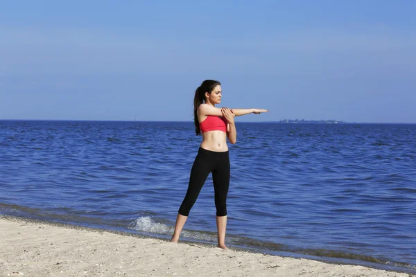 Joven mujer deportiva haciendo ejercicio en la playa — Foto de Stock