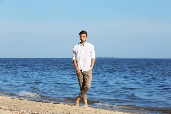 Hombre joven caminando en la playa —  Fotos de Stock