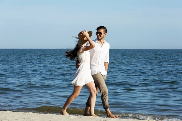 Young couple walking on beach — Stock Photo, Image